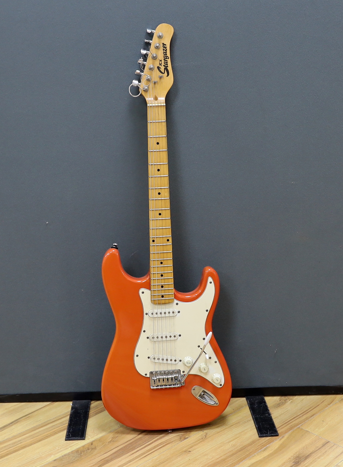 A JCX Stargazer electric guitar with maple neck and orange lacquered body